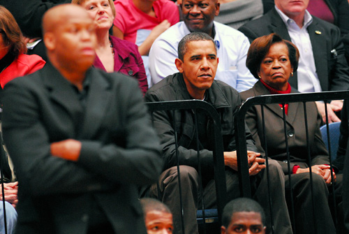 President Obama and his family are seated behind the visitors' bench with a section of Oregon State fans.