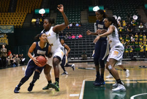 Then-junior guard Chakecia Miller squeezes pass a George Mason defender for a layup in a January game. File Photo by Aly Kruse | Hatchet Photographer