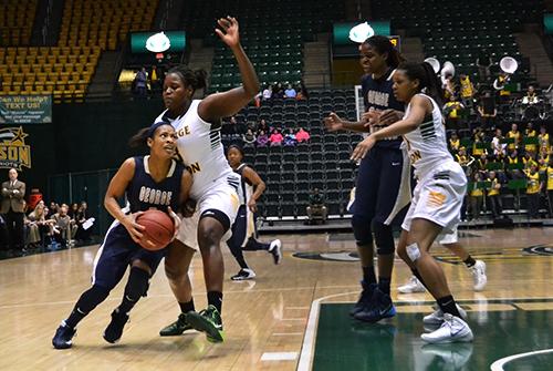 Then-junior guard Chakecia Miller squeezes pass a George Mason defender for a layup last season. File Photo by Aly Kruse | Hatchet Photographer