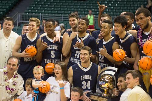 Members of the men's basketball team and coach Mike Lonergan's family pose with the Diamond Head Classic championship trophy after defeating No. 11 Wichita State 60-54. Nora Princiotti | Hatchet Staff Photographer