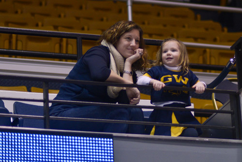 Lisa DeBow, an alumna from the Class of 1997, and her daughter Caroline DeBow Rohen, dressed as a GW cheerleader, cheer on the Colonials. 
