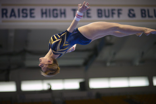 Junior Taylor Redmond goes airborne as she dismounts from the uneven bars. 